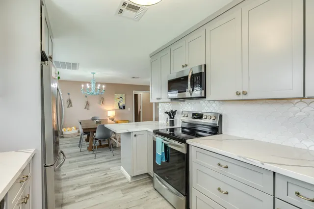 a kitchen with appliances a sink and cabinets
