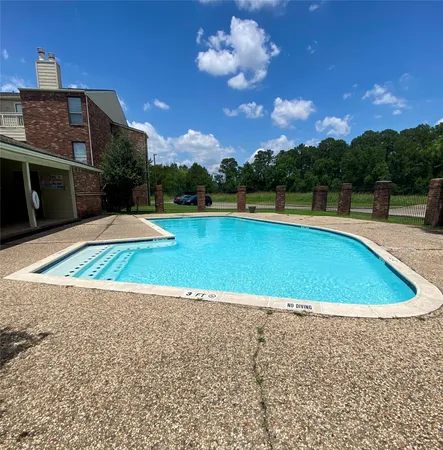 a view of a swimming pool with a yard and plants