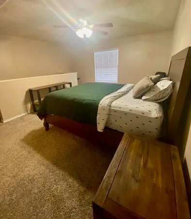 a bedroom with a bed and teddy bear on bed
