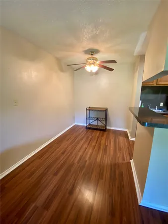 a view of a room with wooden floor and ceiling fan
