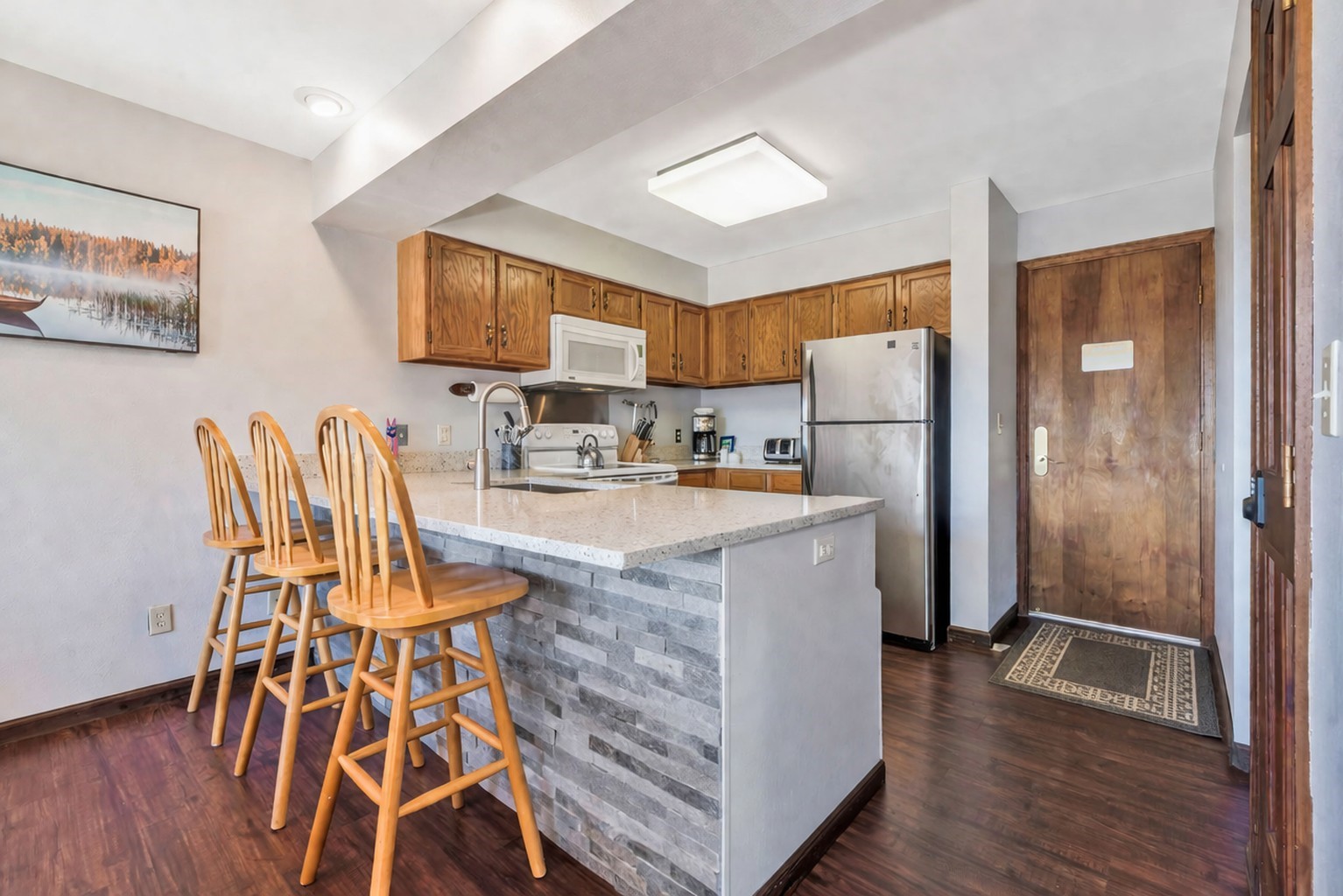 1720 Ranch Road, Unit 309 Steamboat Springs, CO 80487 - Photo 8 of 43 a kitchen with a table chairs refrigerator and wooden floor