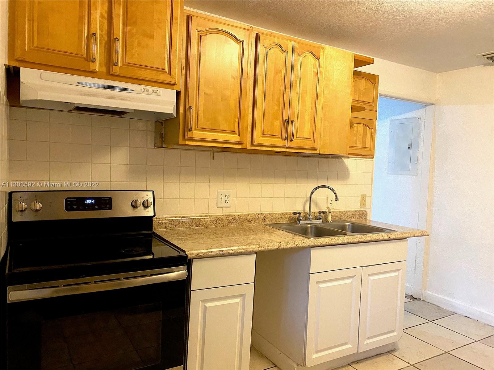 4763 Northwest 3rd Street, Unit 1A Miami, FL 33126 - Photo 12 of 14 a kitchen with stainless steel appliances granite countertop a sink stove and cabinets