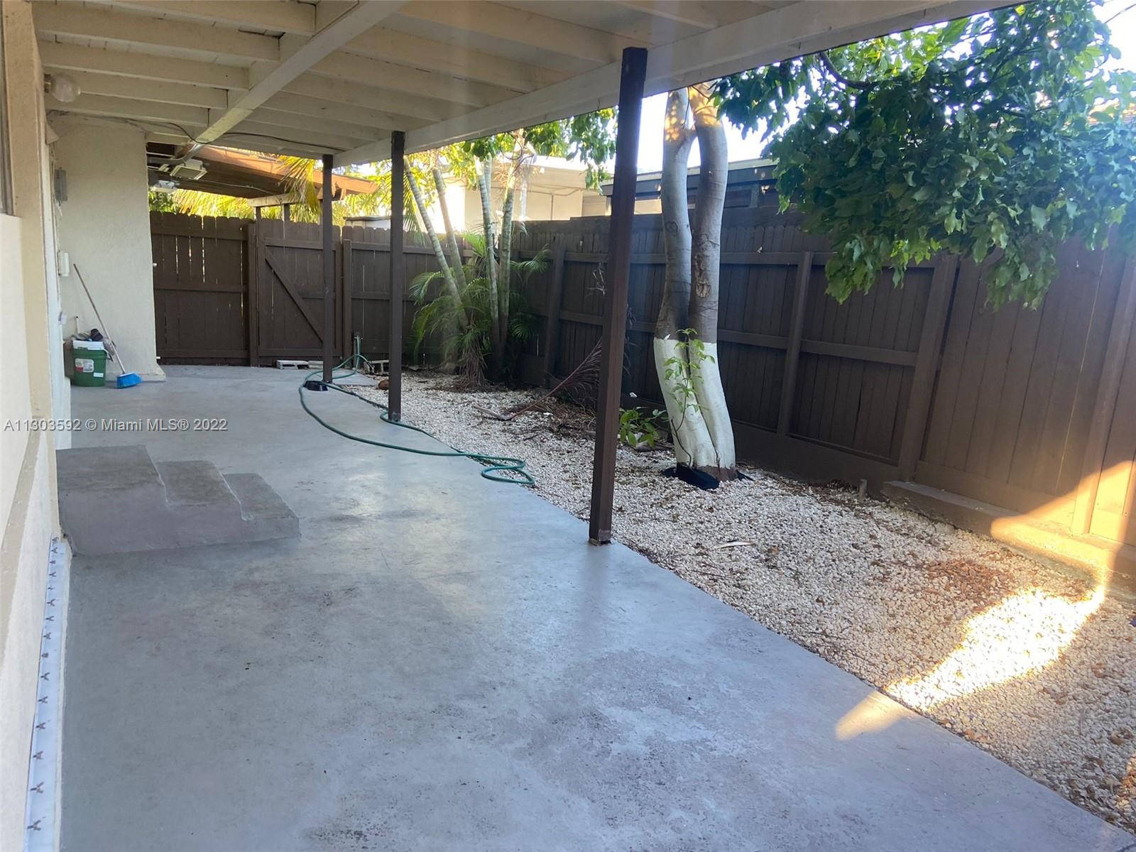 4763 Northwest 3rd Street, Unit 1A Miami, FL 33126 - Photo 2 of 14 a backyard of a house with barbeque oven table and chairs