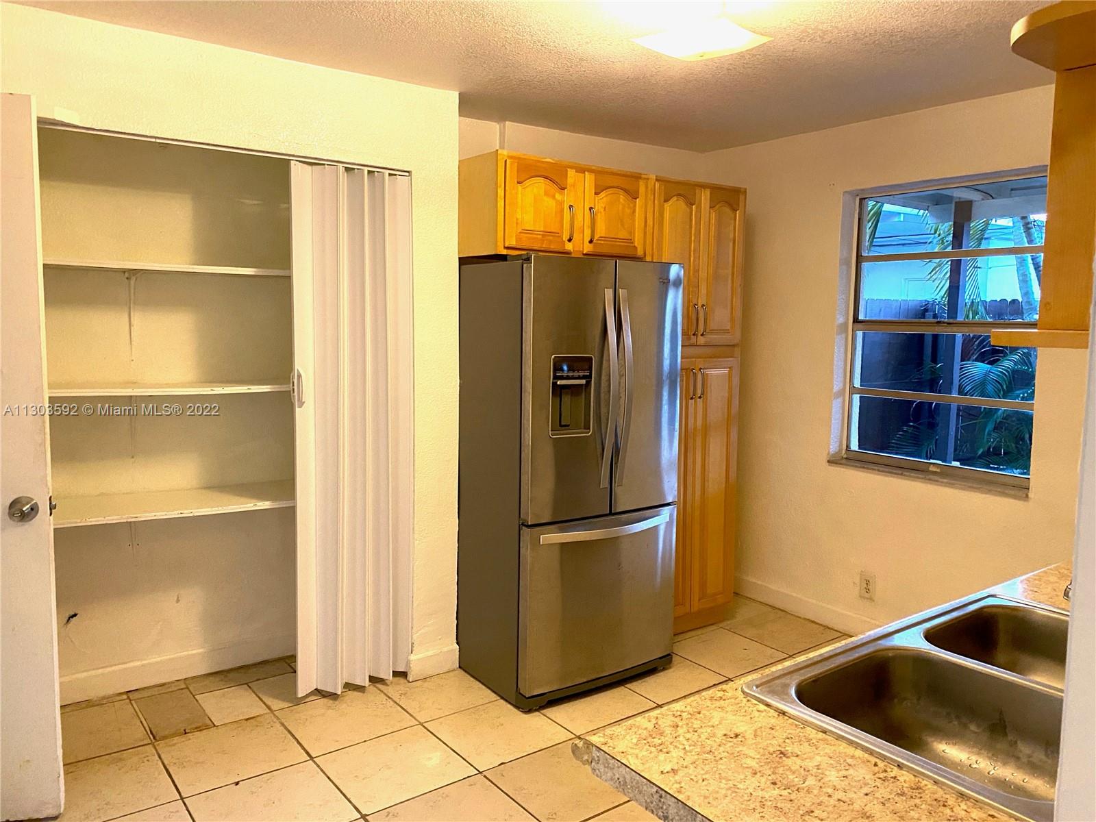 4763 Northwest 3rd Street, Unit 1A Miami, FL 33126 - Photo 8 of 14 a kitchen with stainless steel appliances granite countertop a refrigerator and a sink