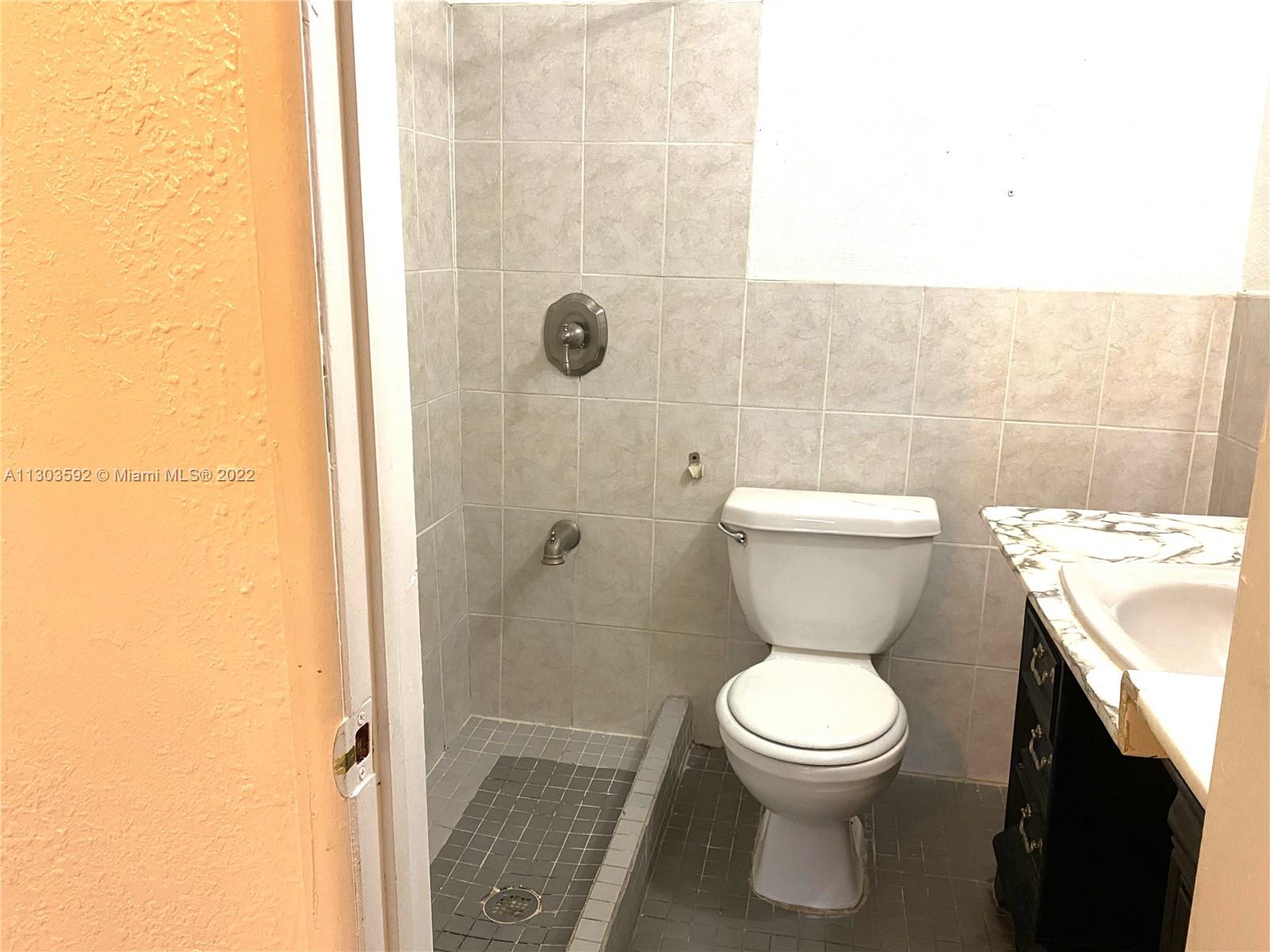 4763 Northwest 3rd Street, Unit 1A Miami, FL 33126 - Photo 9 of 14 a bathroom with a toilet and a shower