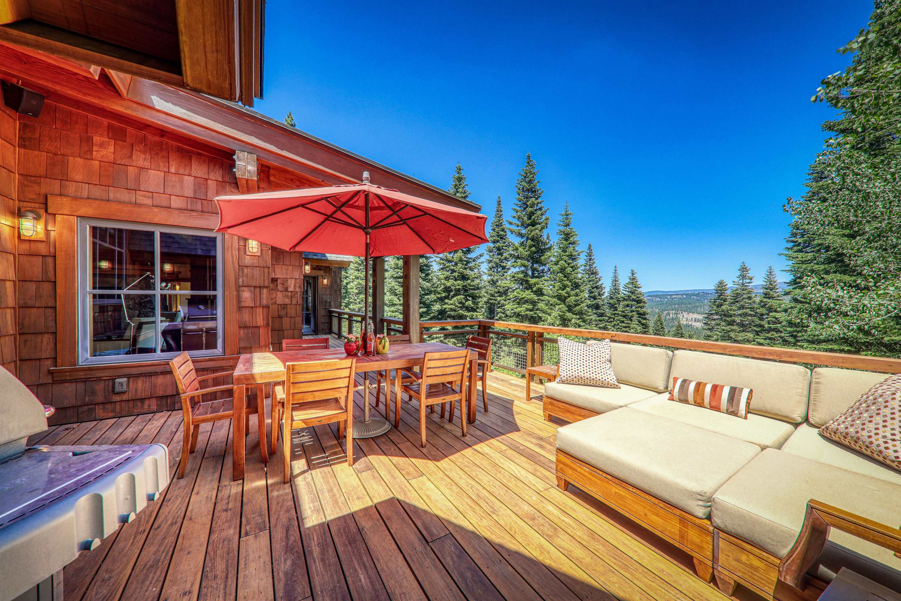 2221 Silver Fox Truckee, CA 96161 - Photo 3 of 28 a view of a patio with couches table and chairs under an umbrella with wooden floor