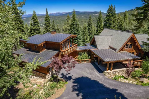 an aerial view of a house with yard and mountain view in back