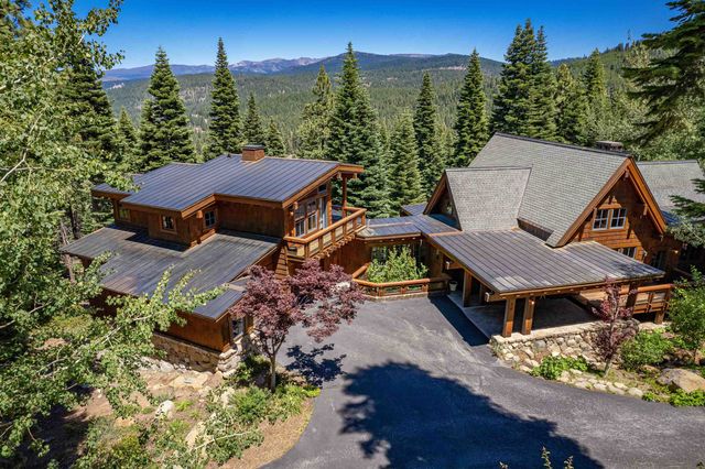 an aerial view of a house with yard and mountain view in back
