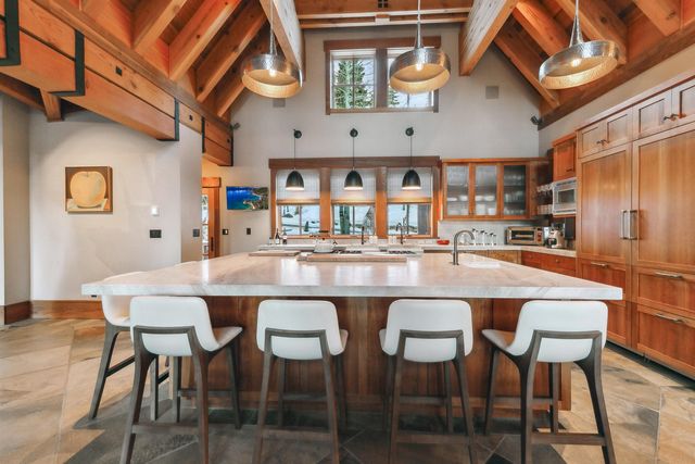 a dining table with chairs and kitchen view