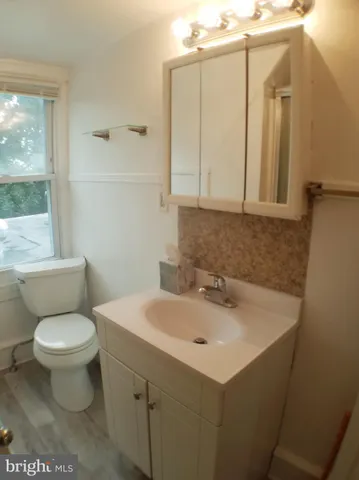 a bathroom with a sink toilet and mirror