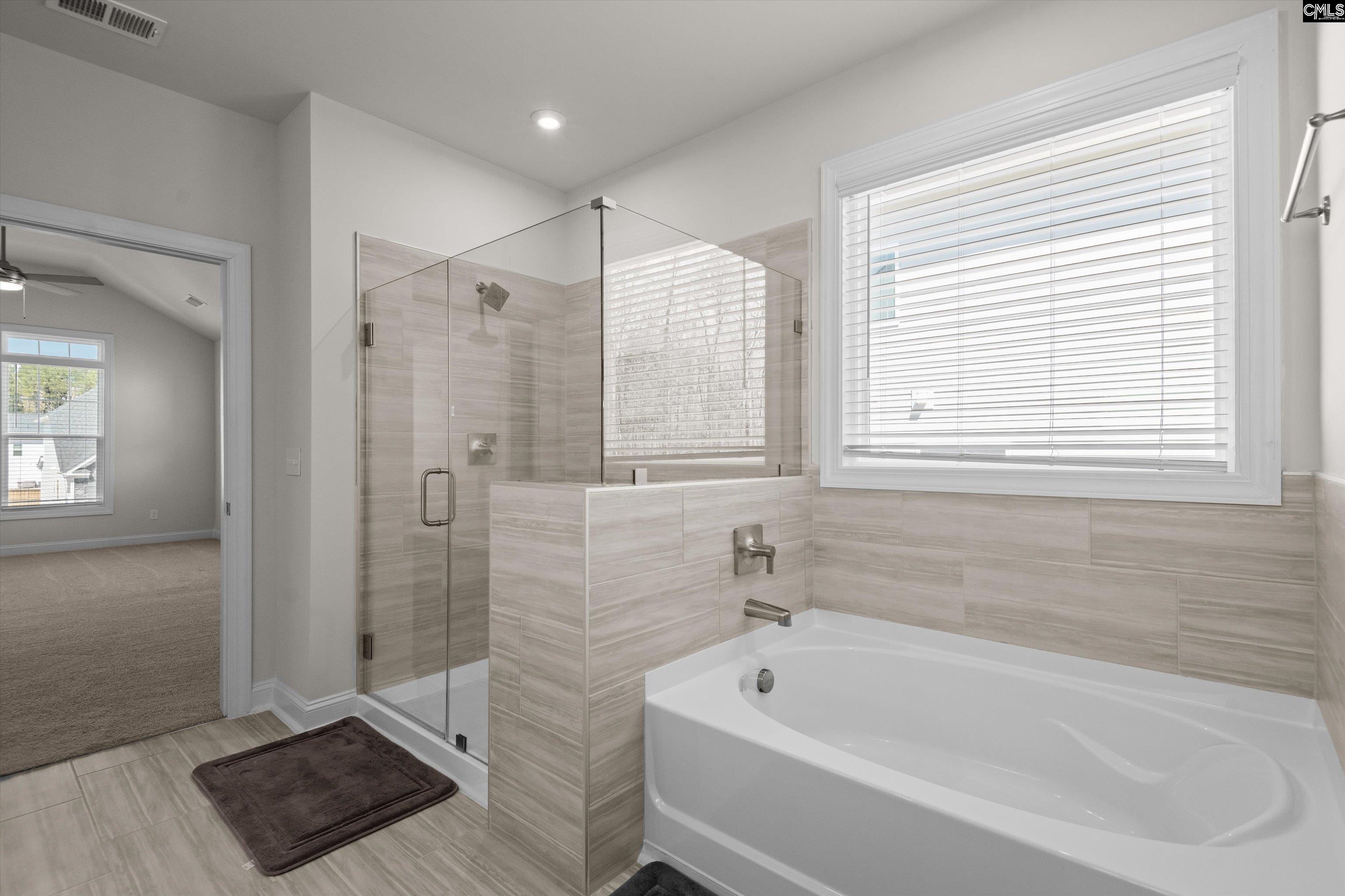 558 Wild Ginger Loop Irmo, SC 29063 - Photo 24 of 42 a bathroom with a tub a sink and a shower