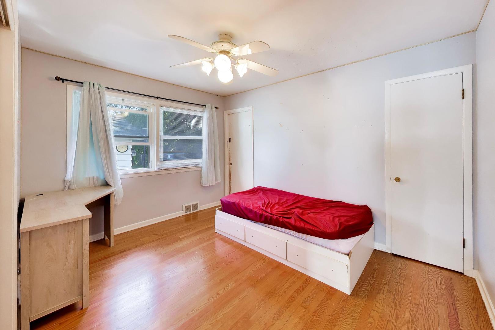 458 West Alma Street Elmhurst, IL 60126 - Photo 10 of 29 a spacious bedroom with a bed and a chandelier