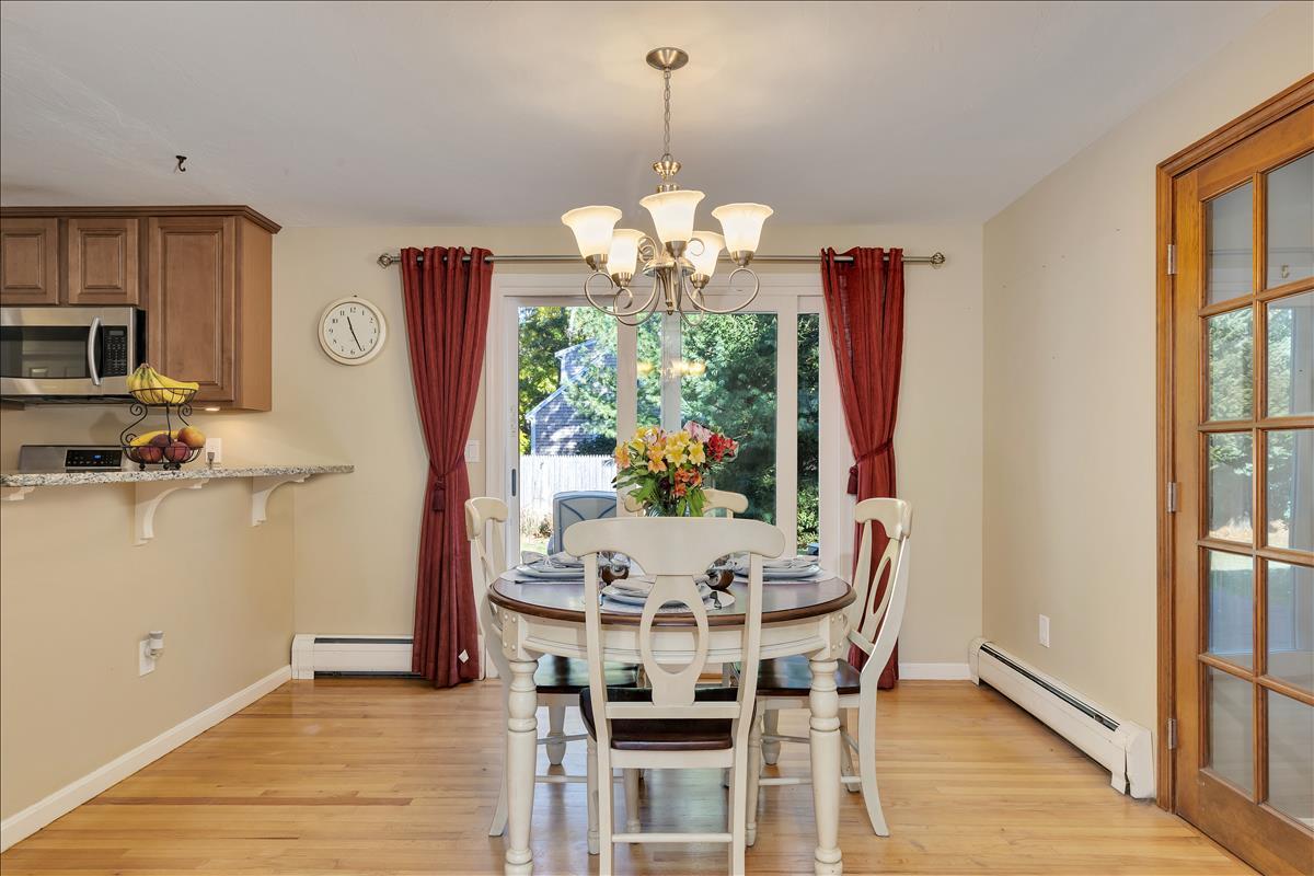 524 Prince Hinckley Road Centerville, MA 02632 - Photo 11 of 43 a view of a dining room with furniture a chandelier and wooden floor