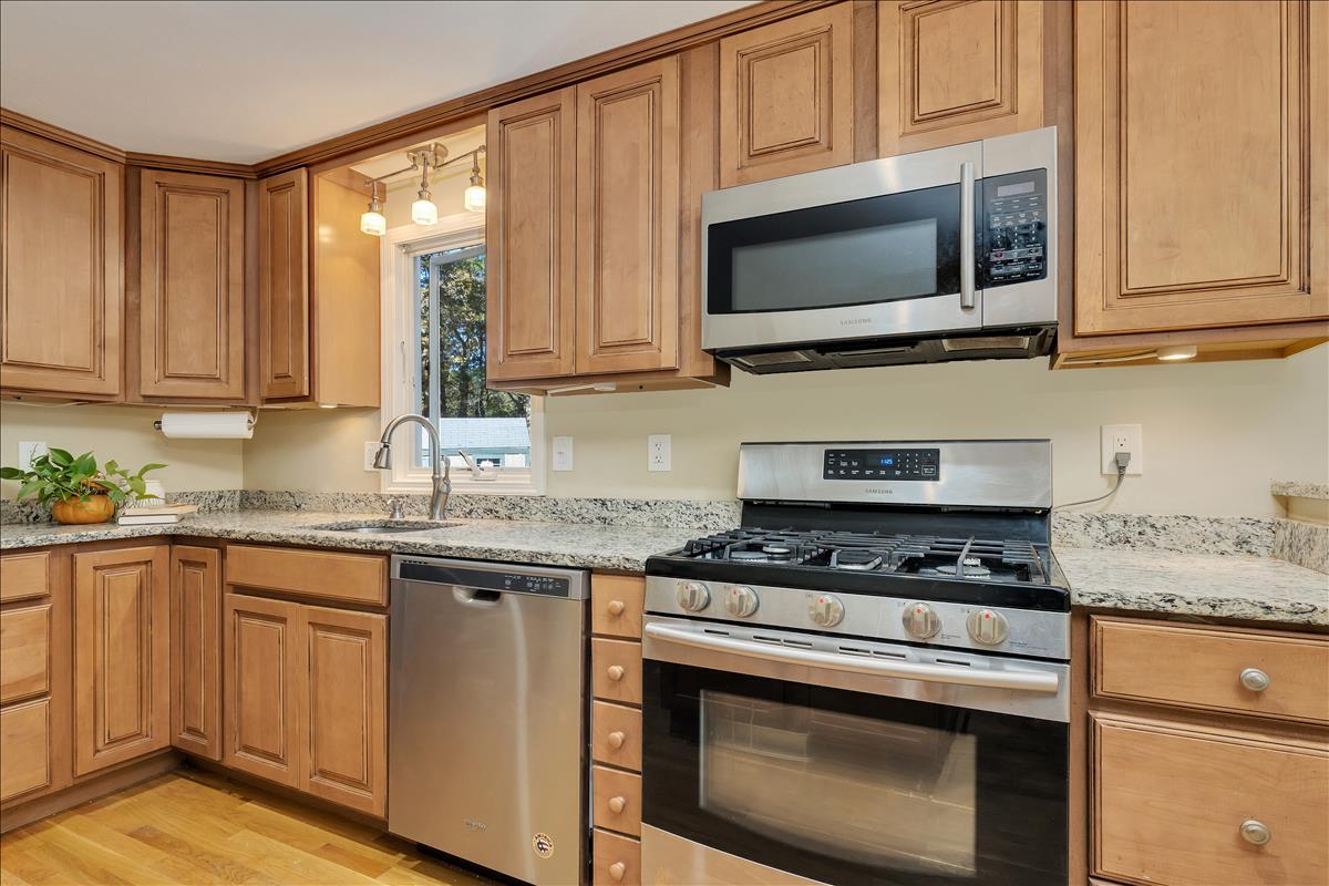 524 Prince Hinckley Road Centerville, MA 02632 - Photo 18 of 43 a kitchen with granite countertop a stove top oven microwave and cabinets