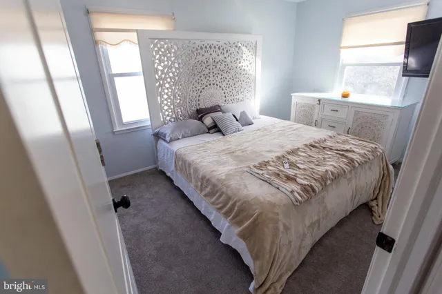 a bed sitting in a bedroom next to a window