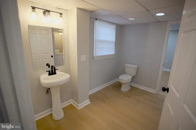 a bathroom with a sink a toilet and a mirror
