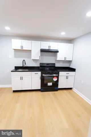 a kitchen with kitchen island a sink a stove and cabinets