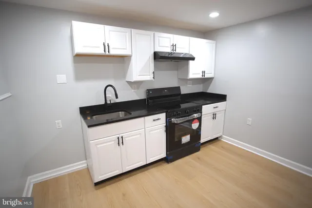 a kitchen with stainless steel appliances granite countertop a sink a stove and a refrigerator