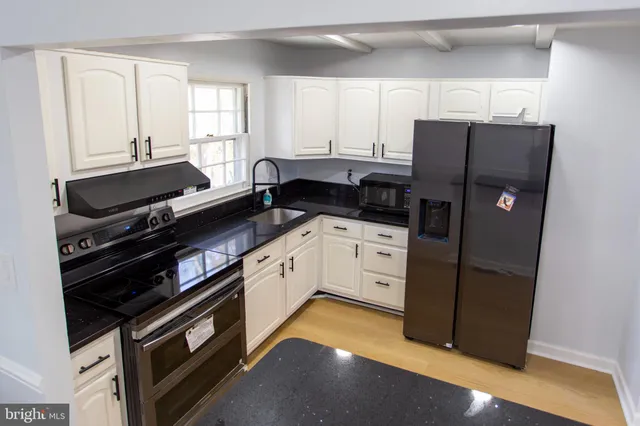 a kitchen with a refrigerator stove and cabinets