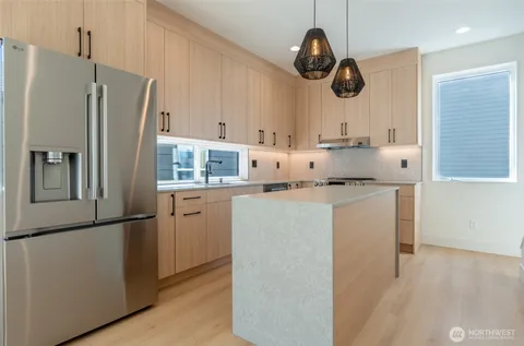 a living room with furniture kitchen view and a large window
