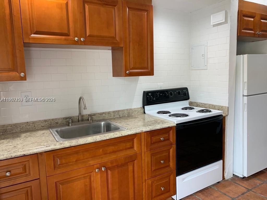 3475 Southwest 1st Avenue, Unit 14 Miami, FL 33145 - Photo 6 of 22 a kitchen with stainless steel appliances granite countertop a sink stove and refrigerator