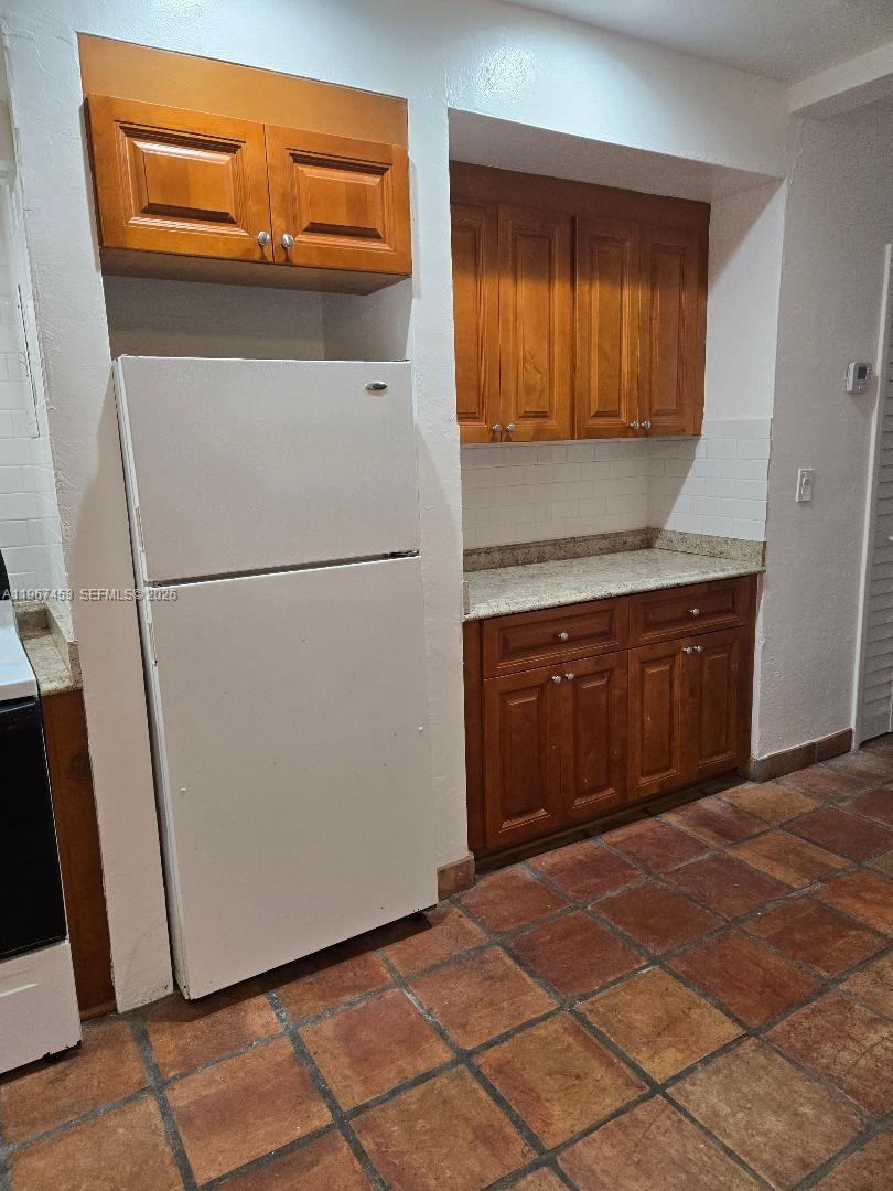 3475 Southwest 1st Avenue, Unit 14 Miami, FL 33145 - Photo 8 of 22 a kitchen with a refrigerator and cabinets