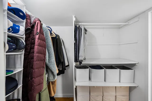 a view of walk in closet with clothes and shoes