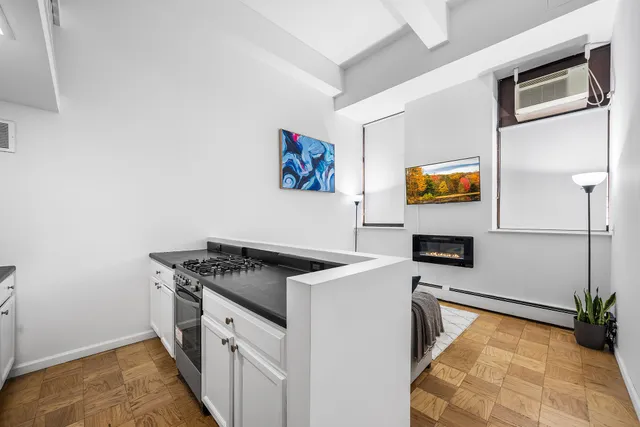 a kitchen with granite countertop a stove a sink and a refrigerator