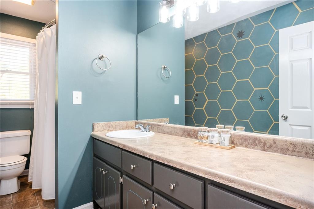 70 Countryside Lane Covington, GA 30016 - Photo 15 of 30 a bathroom with a granite countertop sink a mirror and a toilet