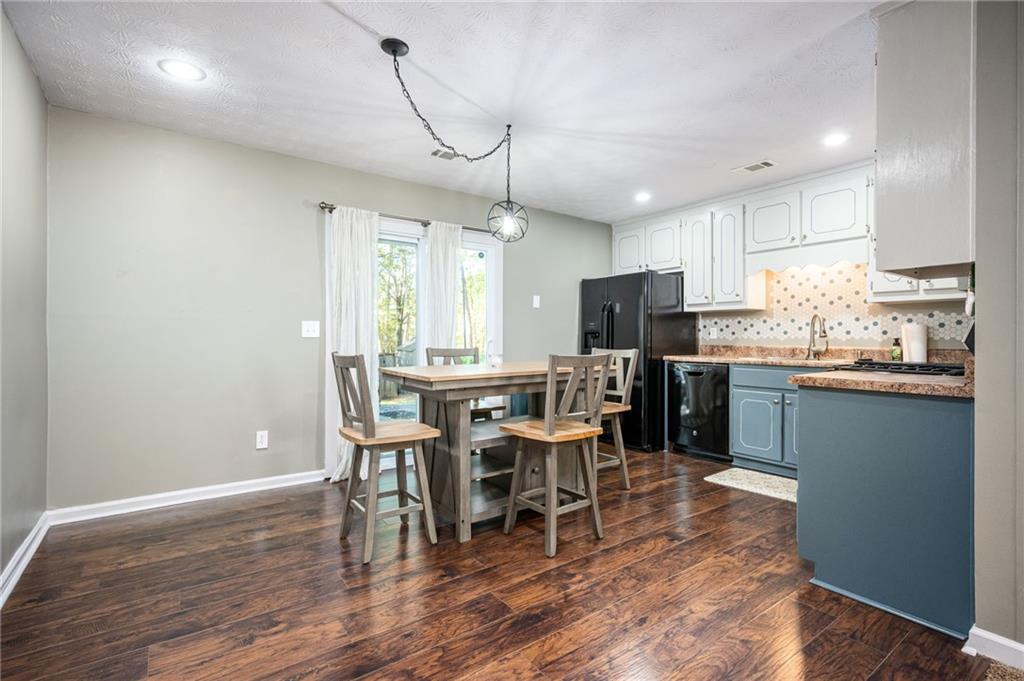 70 Countryside Lane Covington, GA 30016 - Photo 8 of 30 a kitchen with stainless steel appliances granite countertop a stove a refrigerator a kitchen island a dining table and chairs with wooden floor