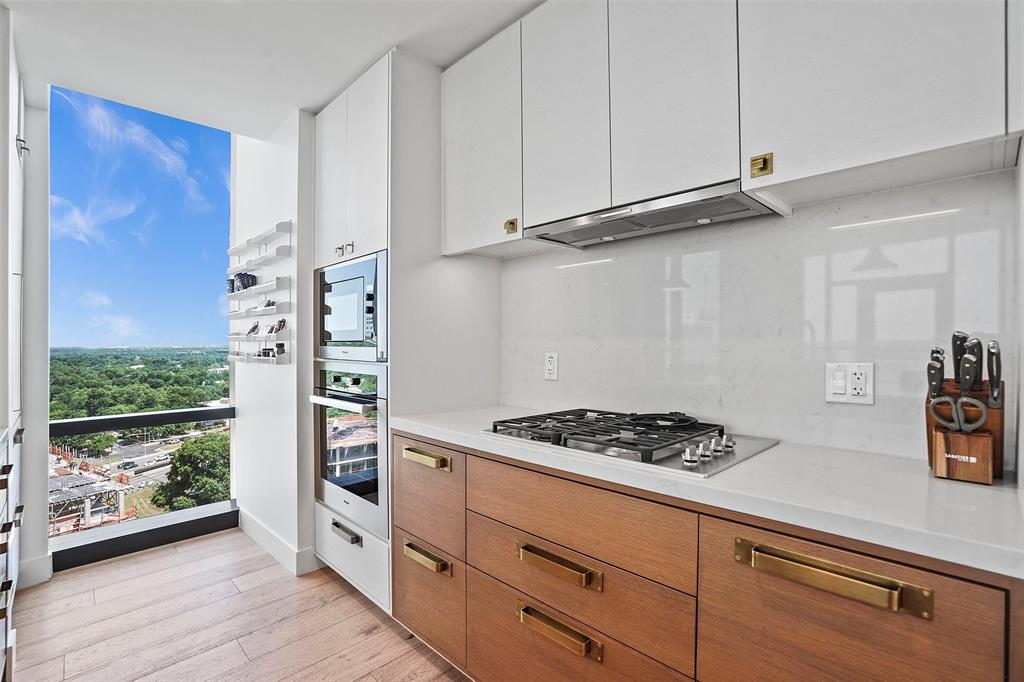 70 Rainey Street, Unit 1409 Austin, TX 78701 - Photo 8 of 38 Kitchen with floor to ceiling windows, light wood-type flooring, white cabinetry, stainless steel appliances, and extractor fan