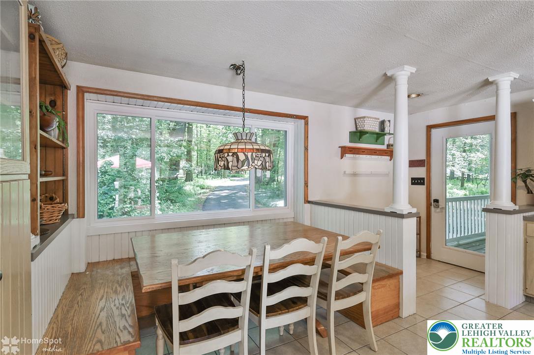 60 Sassafras Road Lehighton, PA 18235 - Photo 18 of 36 A well-lit dining area offers direct outdoor access and views of surrounding natural beauty.