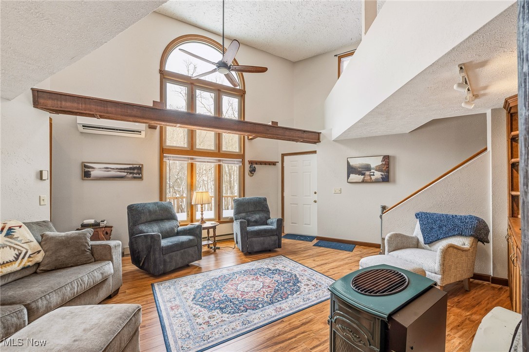 86523 North Bay Road Scio, OH 43988 - Photo 5 of 25 Living area with a textured ceiling, ceiling fan, wood finished floors, high vaulted ceiling, and a wall unit AC