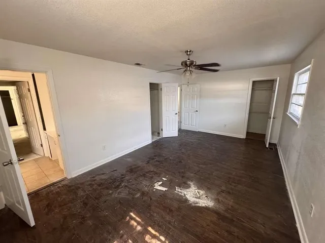 a view of a hallway to a livingroom with wooden floor and stairs