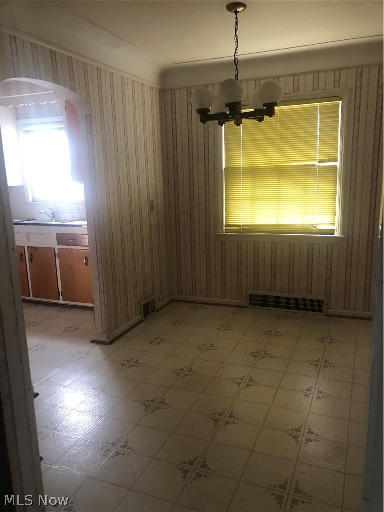 4037 Wilmington Road Cleveland, OH 44121 - Photo 13 of 36 Unfurnished dining area with light flooring, hanging lights, and wooden walls