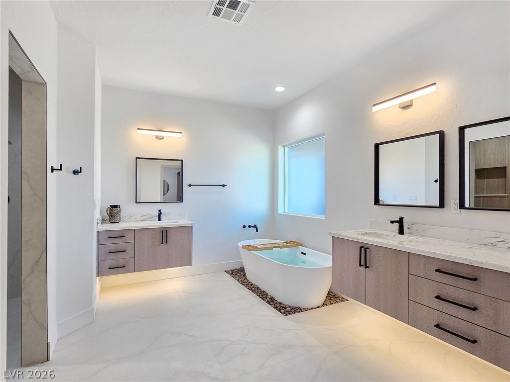 1120 West Gamebird Road Pahrump, NV 89048 - Photo 29 of 36 Full bathroom with two vanities, a soaking tub, light marble finish floors, and recessed lighting