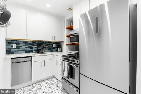 a kitchen with stainless steel appliances granite countertop a refrigerator sink and stove