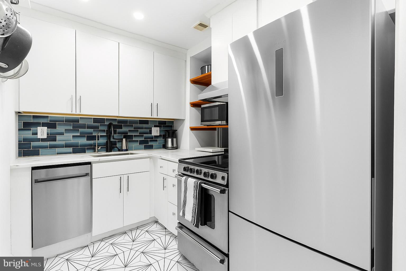 1903 Spruce Street, Unit 1A Philadelphia, PA 19103 - Photo 8 of 22 a kitchen with stainless steel appliances granite countertop a refrigerator sink and stove