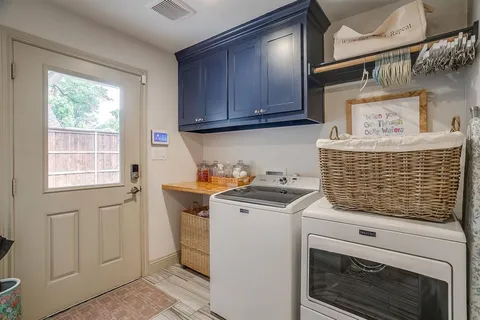 a view of washer and dryer with wooden cabinet