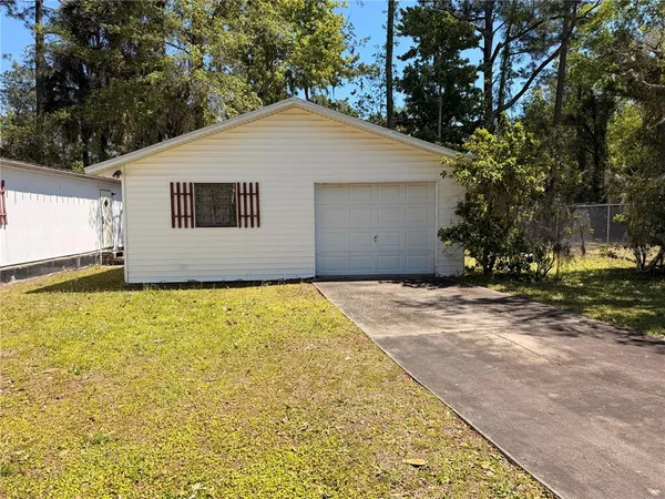 a front view of house along with trees