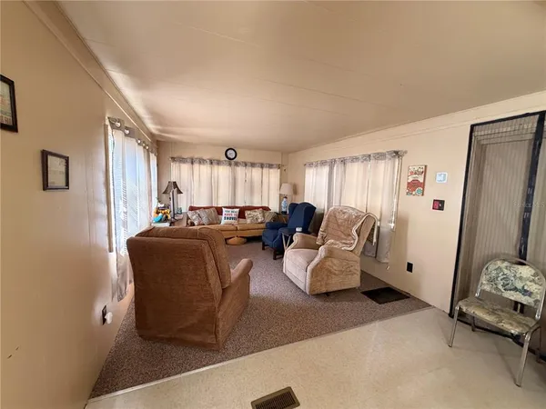 a living room with furniture windows and a flat screen tv