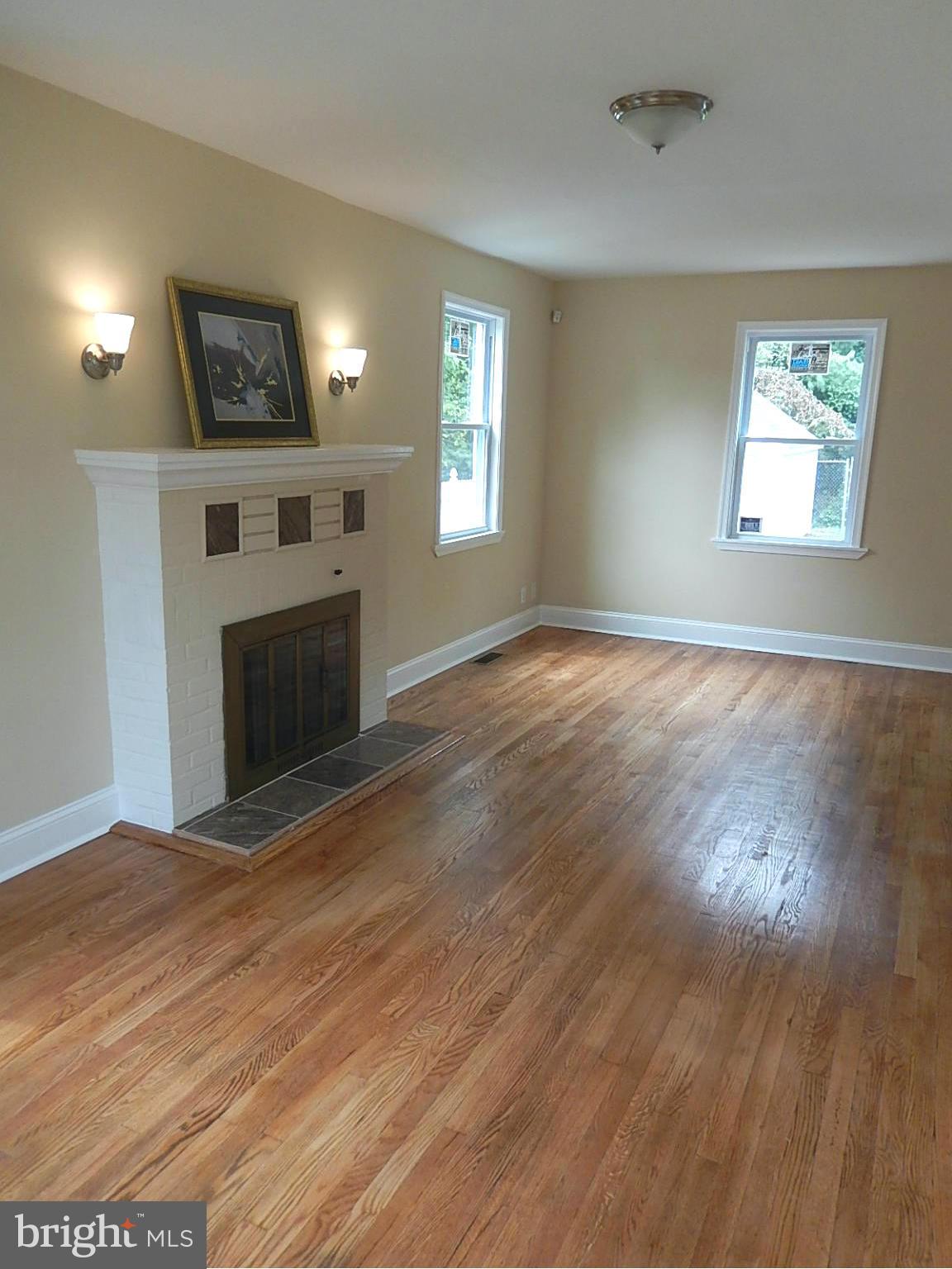 622 Warwick Road Baltimore, MD 21229 - Photo 15 of 29 a view of empty room with wooden floor and fireplace