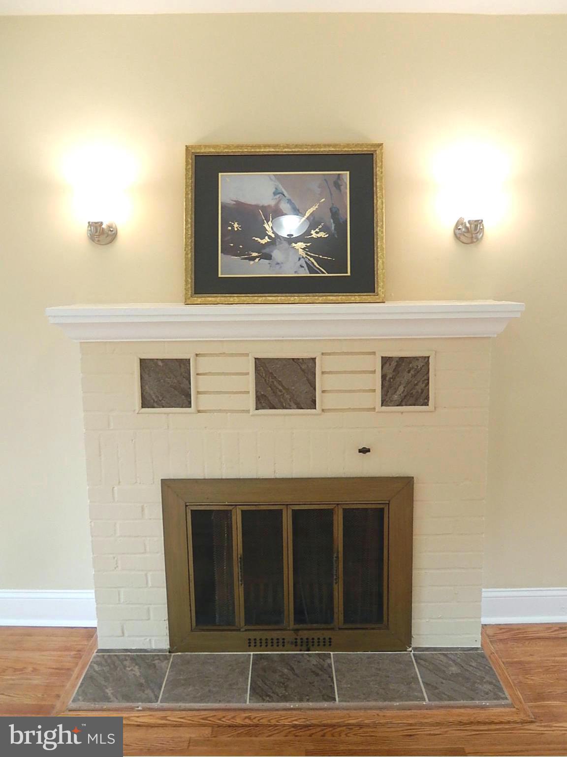 622 Warwick Road Baltimore, MD 21229 - Photo 16 of 29 a view of a hallway with wooden floor and a fireplace