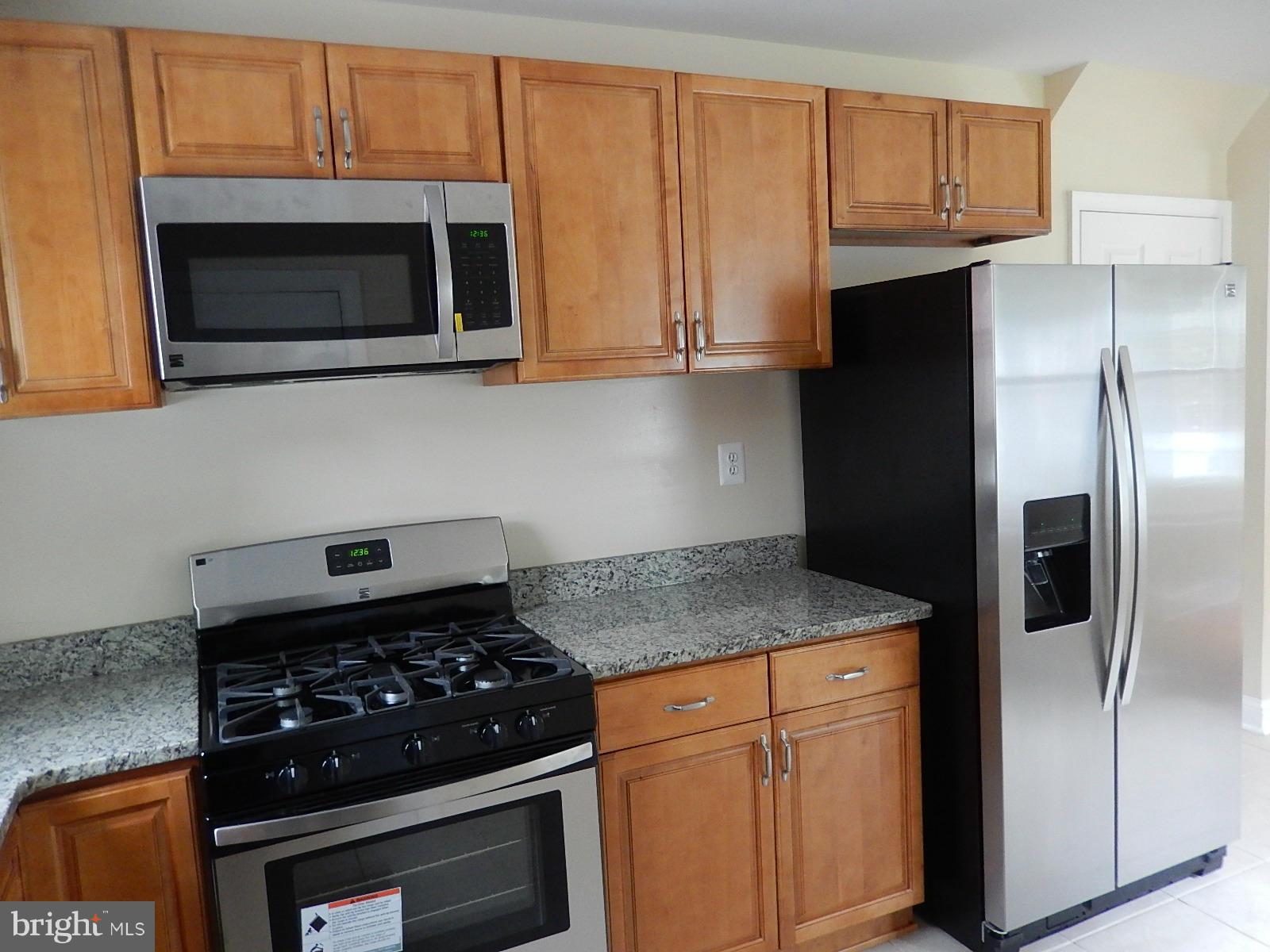622 Warwick Road Baltimore, MD 21229 - Photo 22 of 29 a kitchen with stainless steel appliances granite countertop a stove a microwave and a refrigerator