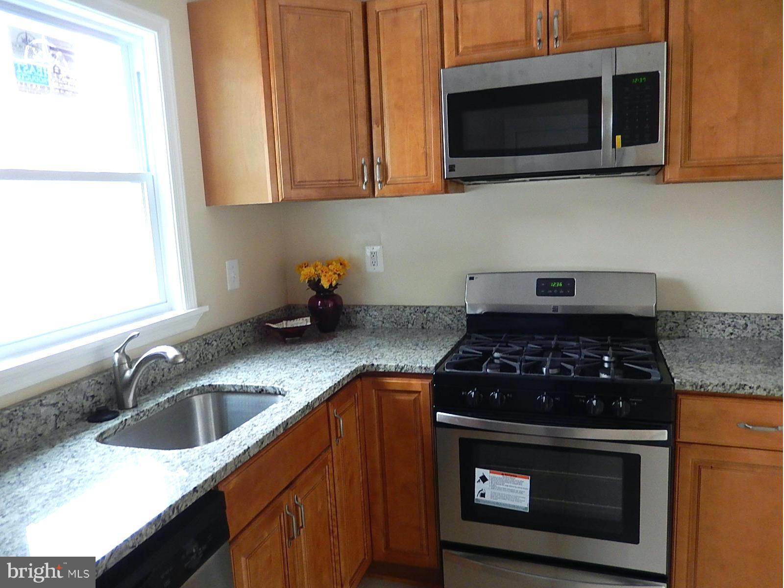 622 Warwick Road Baltimore, MD 21229 - Photo 23 of 29 a kitchen with stainless steel appliances a stove a microwave a sink and cabinets