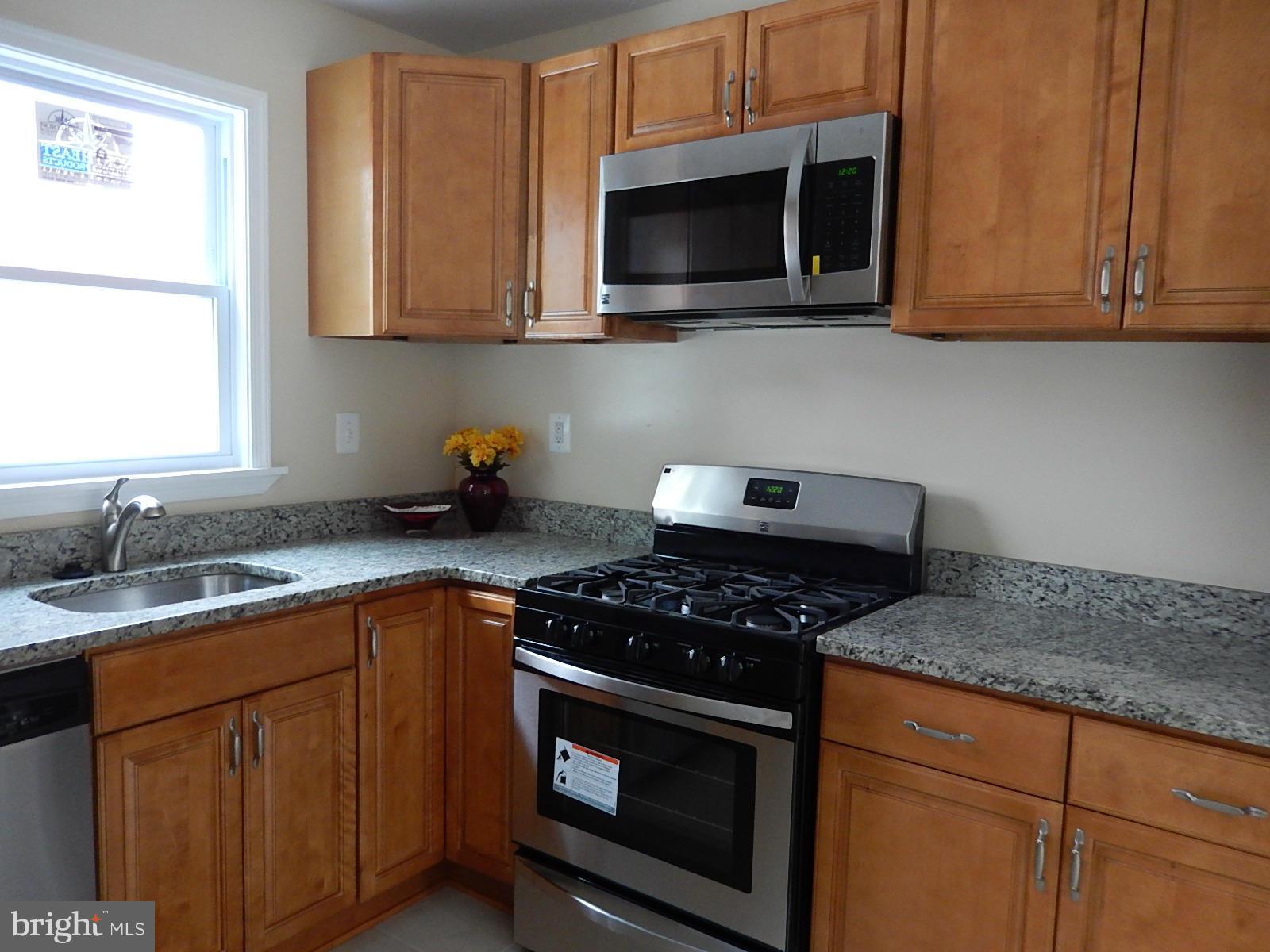 622 Warwick Road Baltimore, MD 21229 - Photo 4 of 29 a kitchen with stainless steel appliances granite countertop a sink stove top oven and microwave