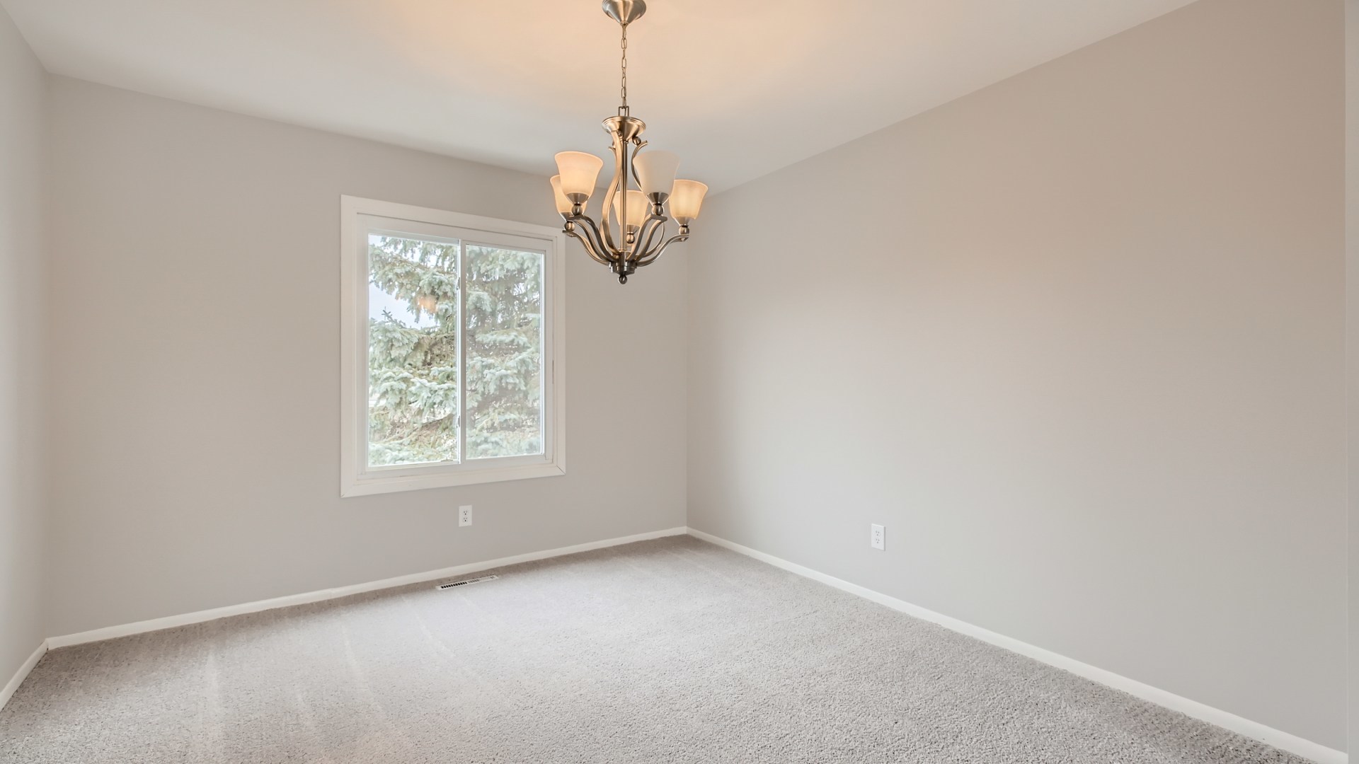 17 Windgate Court Streamwood, IL 60107 - Photo 8 of 28 en empty room with windows and chandelier