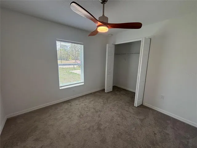 a view of a room with a ceiling fan and a window