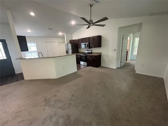 a view of kitchen with refrigerator and microwave