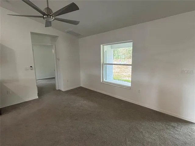 an empty room with a window and a fan